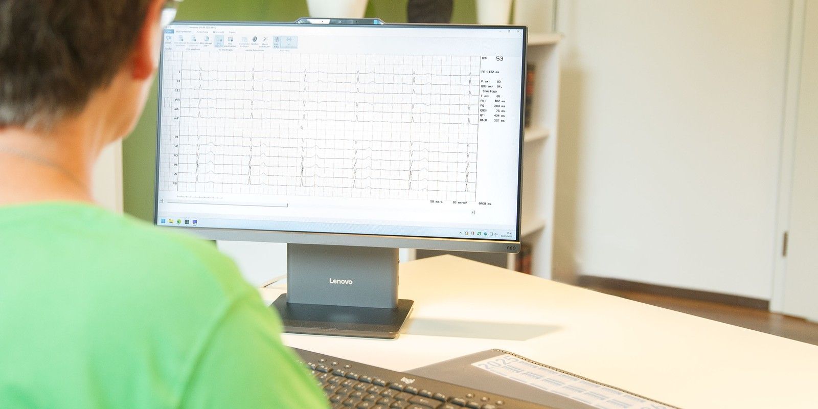 Arzthelferin schaut am Bildschirm ein EKG an